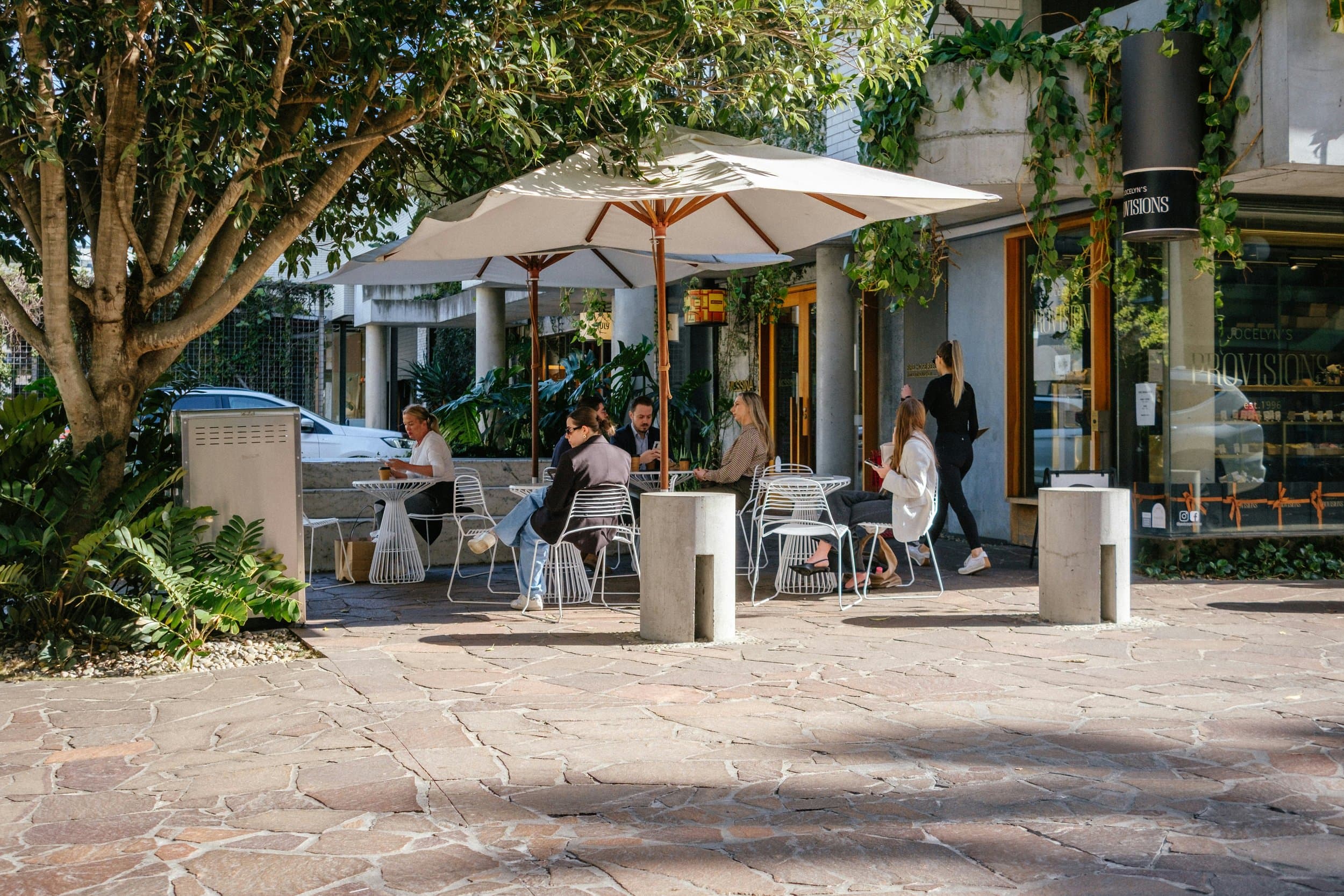 Outdoor seating area of a cafe with white tables and chairs